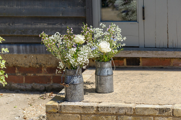 Flowers in old metal milk jugs