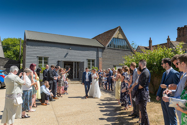 Bride & Groom walking past lines of guests