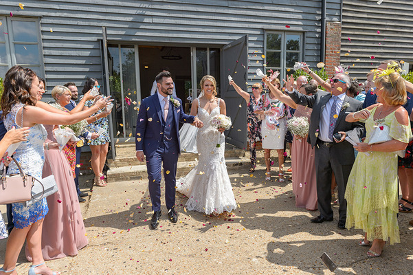 Guests throwing confetti over bride and groom